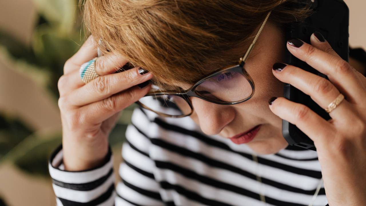 Mulher preocupada falando ao telefone