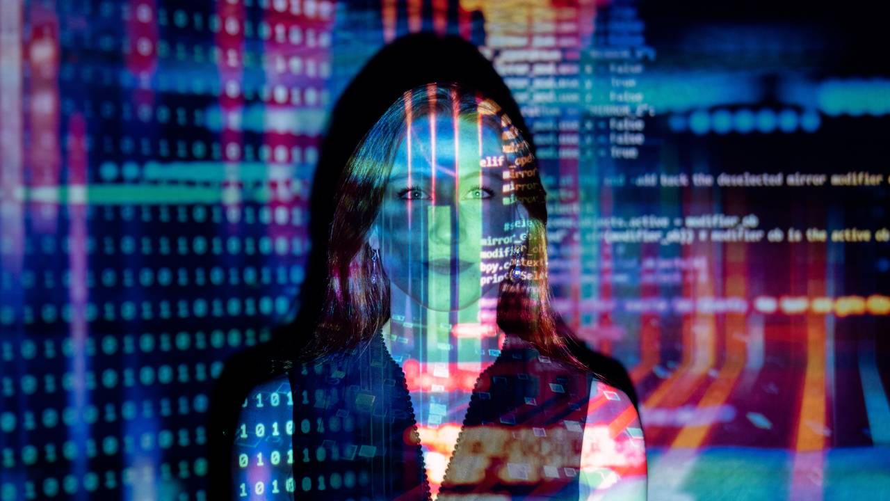 Imagem mostra sobreposição de rosto de mulher com códigos de computador