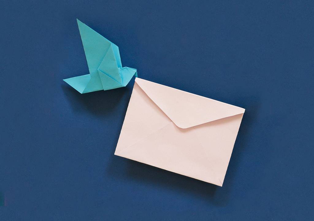 Um pássaro de origami carregando uma carta de papel.